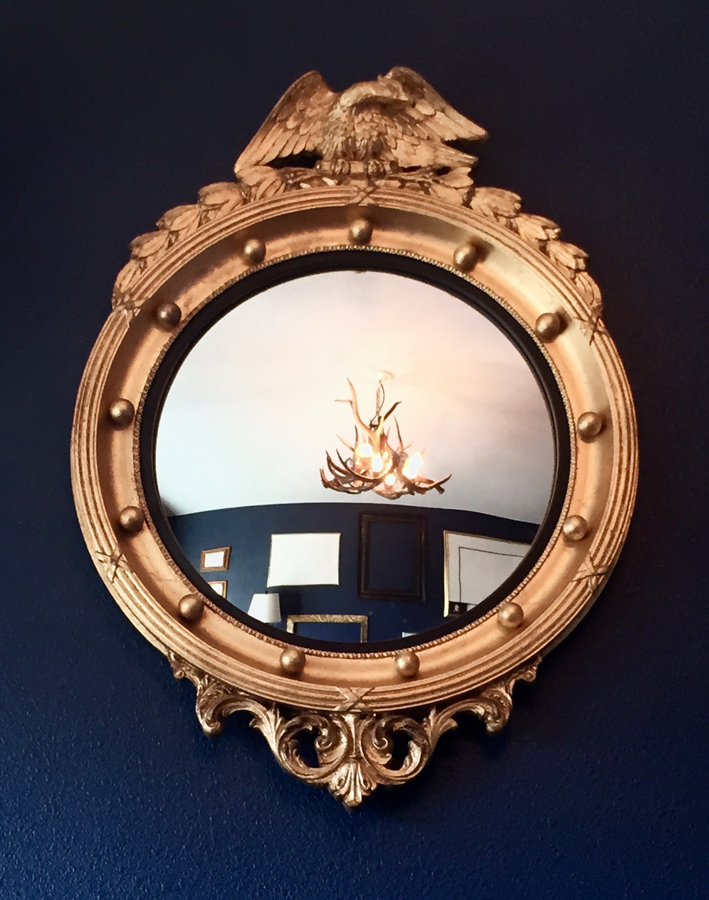 Davis Navy wall color with federal convex gold mirror, chandelier in reflection as well as interior decor